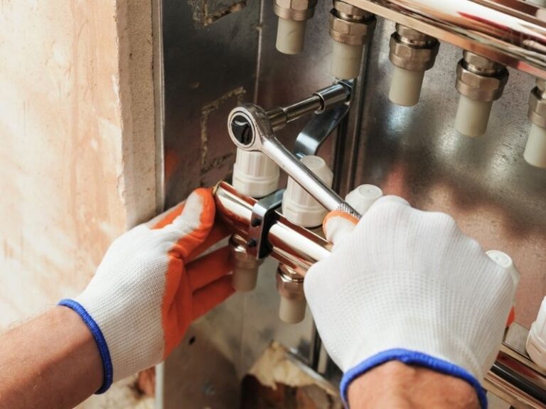 Gloved hands servicing a furnace burner assembly during heating maintenance